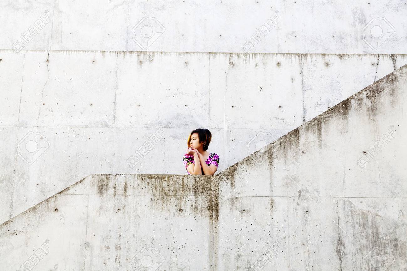 37120630-asian-american-woman-surrounded-by-cement-walls.jpg